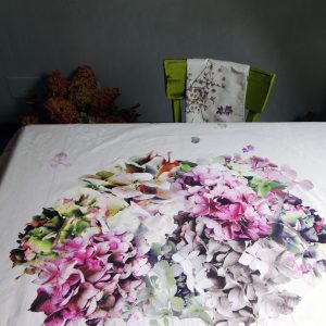 Nappe carrée 100% coton, motif floral Hortensias où se mêlent des teintes de verts, roses, violets, sépia, blanc cassé sur fond écru - 145 x145 cm
