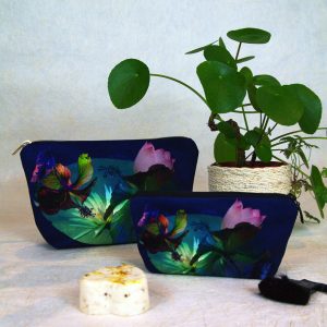Trousse de voyage velours, fermeture zip, motif fleurs et feuillages exotiques, où se mêlent des tons de turquoise, vert, mauve, rose sur fond bleu – 9x17x29cm